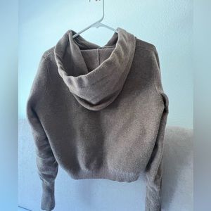 Cropped light brown sweater. Has a hoodie and long sleeves.